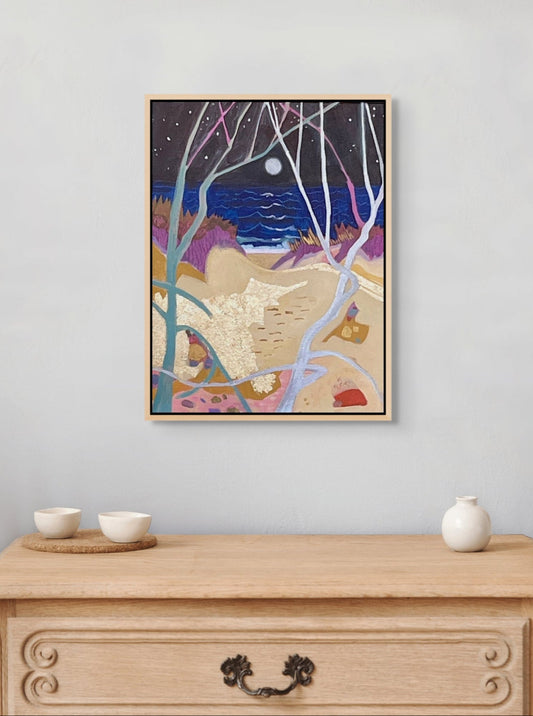 Framed artwork of a night scene with trees and moon on a wall above a wooden dresser.